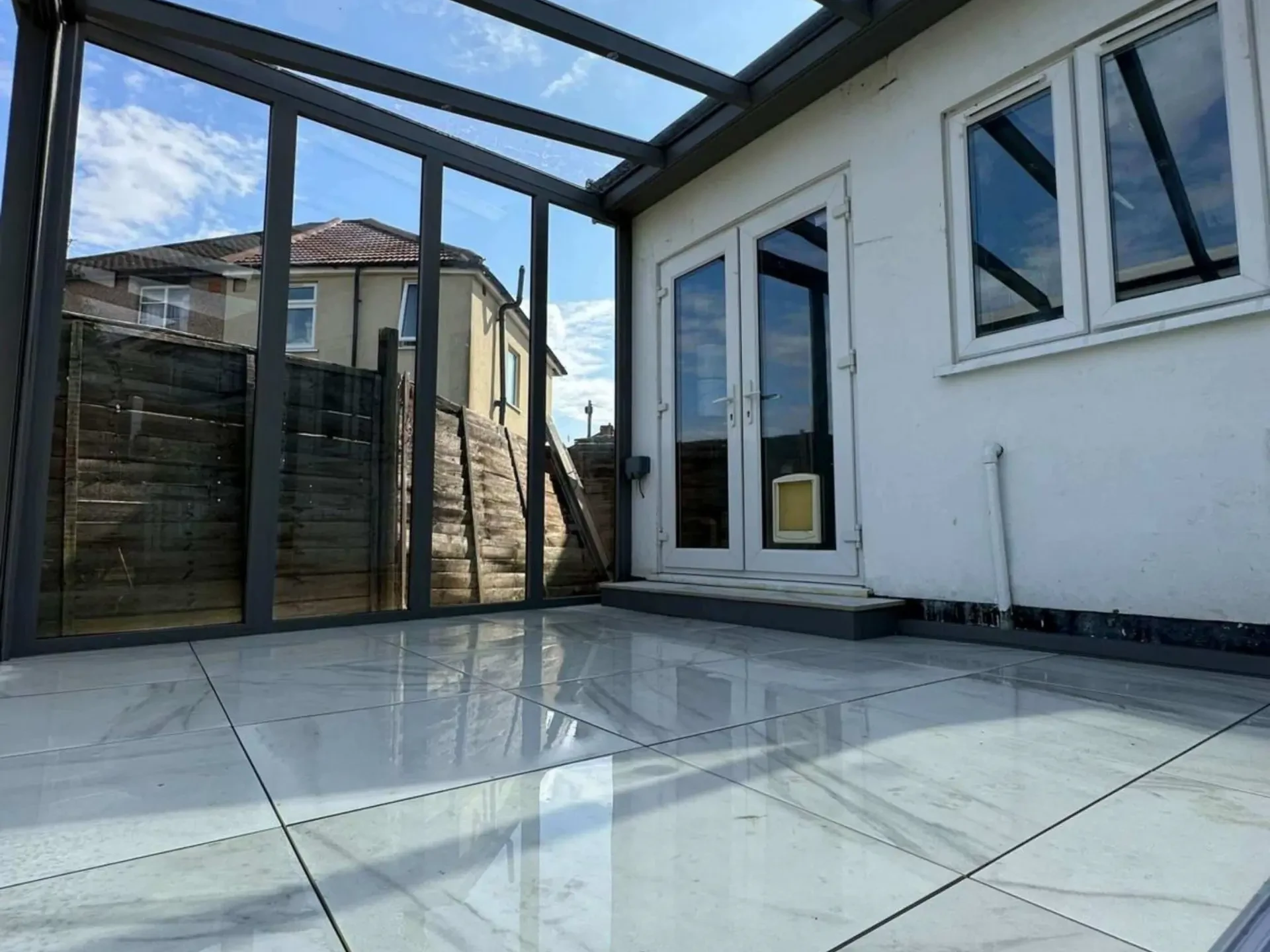 Anthracite grey frame glass room veranda with glass sliding doors, safety glass roof and LED spot lights