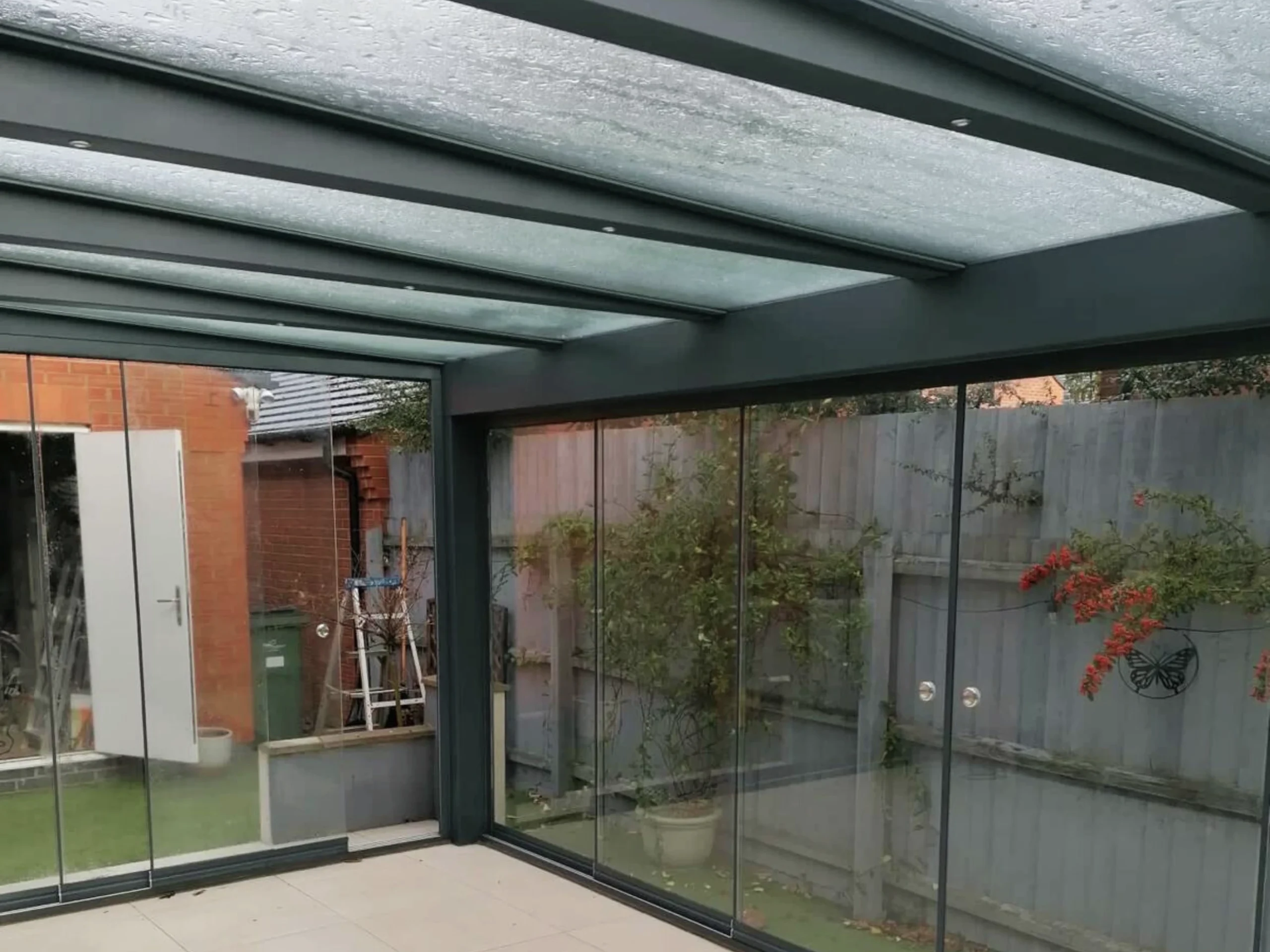 Anthracite grey glass room veranda with glass roof, sliding doors and LED spot lights.
