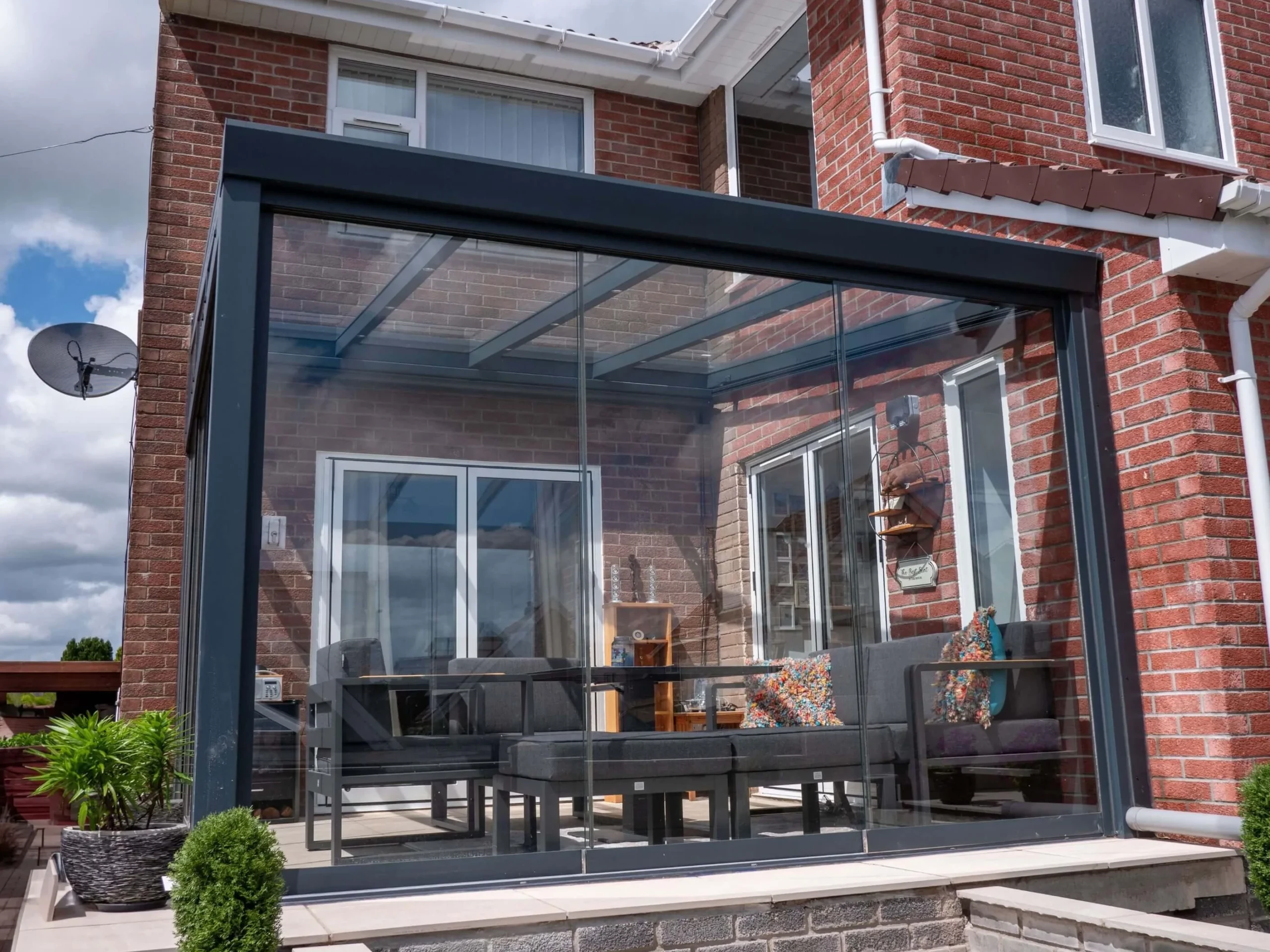 Anthracite grey aluminium framed glass room veranda with lockable glass sliding doors on 2 openings.