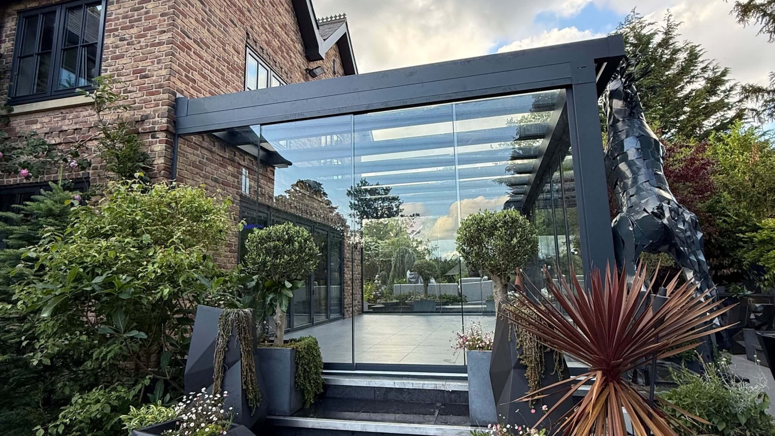 Anthracite grey glass room veranda with clear glass roof and sliding doors.