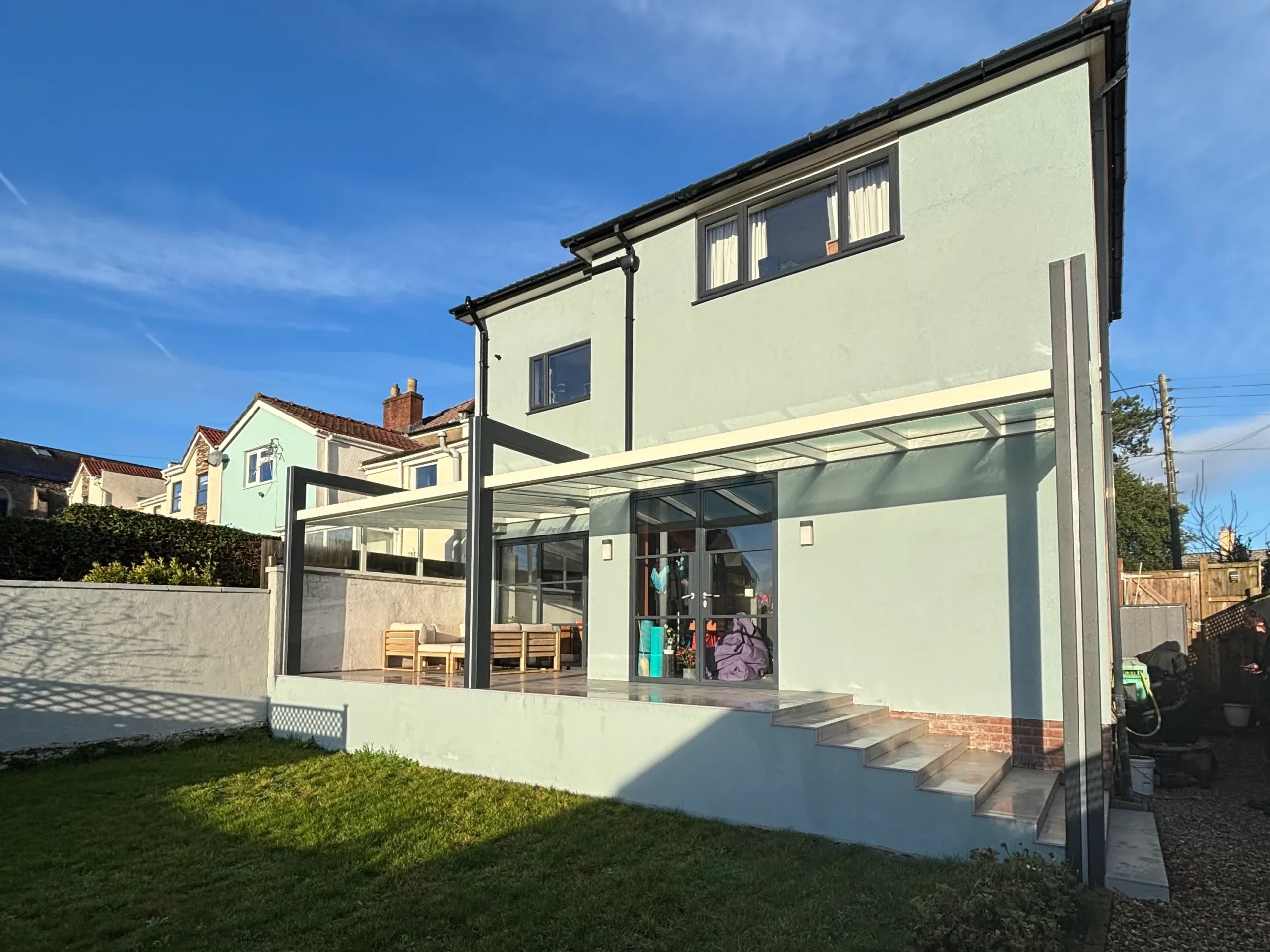 Glass roof veranda with an off white and anthracite grey aluminium frame, plus integrated LED strip lighting.